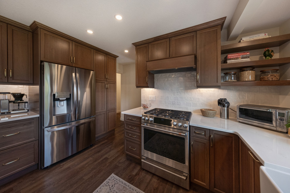 Exempel på ett mellanstort klassiskt vit vitt kök, med en rustik diskho, luckor med infälld panel, skåp i mörkt trä, bänkskiva i kvarts, vitt stänkskydd, stänkskydd i keramik, rostfria vitvaror, vinylgolv, en köksö och brunt golv