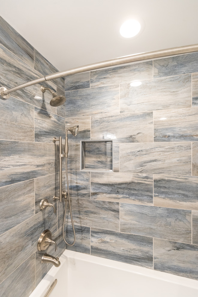 Mid-sized transitional master bathroom in DC Metro with shaker cabinets, dark wood cabinets, an alcove tub, a shower/bathtub combo, a two-piece toilet, multi-coloured tile, porcelain tile, grey walls, an undermount sink, quartzite benchtops and a shower curtain.