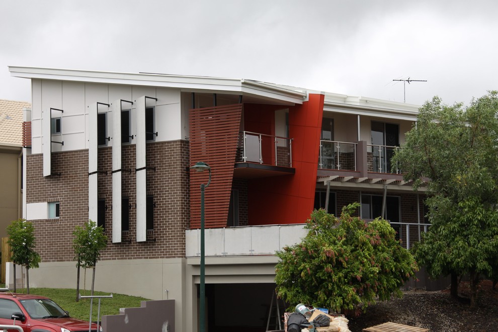 Design ideas for a large contemporary three-storey brick beige exterior in Brisbane.