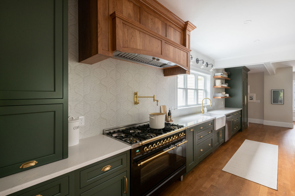 Huge transitional medium tone wood floor and brown floor eat-in kitchen photo in Boston with a farmhouse sink, shaker cabinets, green cabinets, quartz countertops, beige backsplash, an island and white countertops