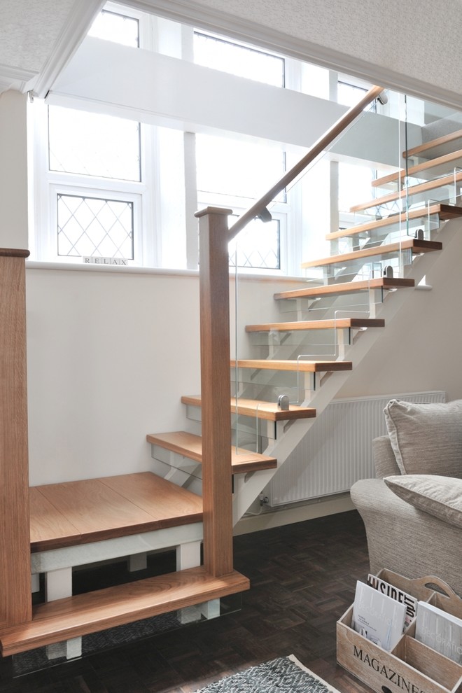 Inspiration for a mid-sized contemporary wood l-shaped staircase in Cardiff with glass risers and wood railing.