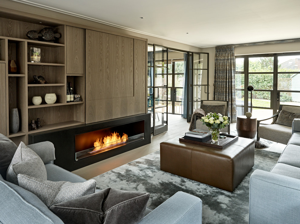 Inspiration for a mid-sized contemporary enclosed family room in London with a ribbon fireplace and a concealed tv.