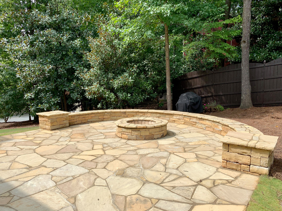 Inspiration for a mid-sized country backyard patio in Atlanta with a fire feature and natural stone pavers.