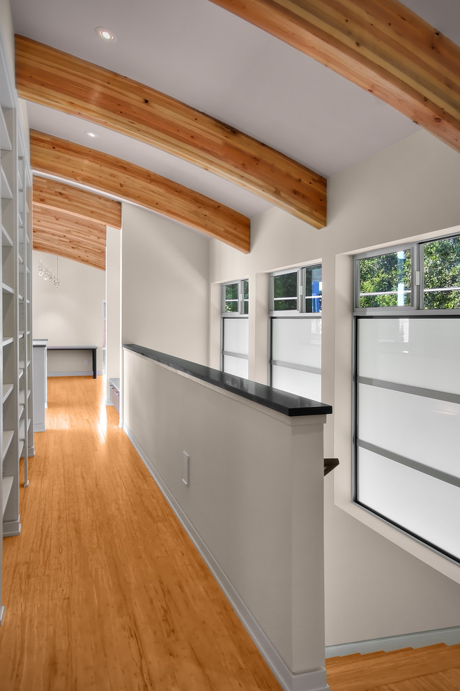 This is an example of a mid-sized contemporary hallway in Seattle with white walls and medium hardwood floors.