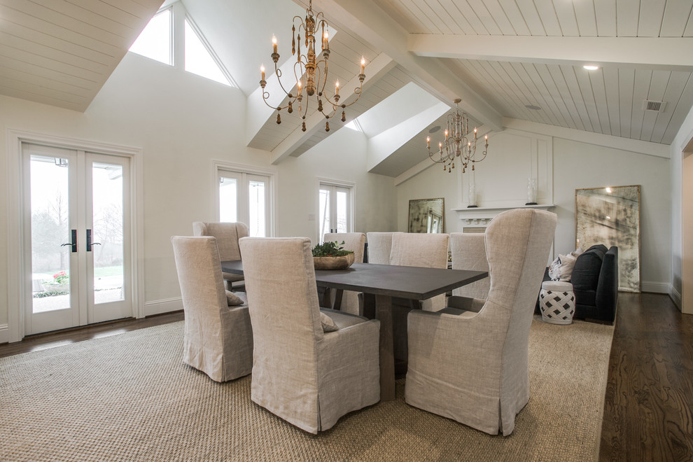 Aménagement d'une grande salle à manger ouverte sur le salon contemporaine avec un mur blanc, un sol en bois brun, une cheminée standard et un manteau de cheminée en pierre.