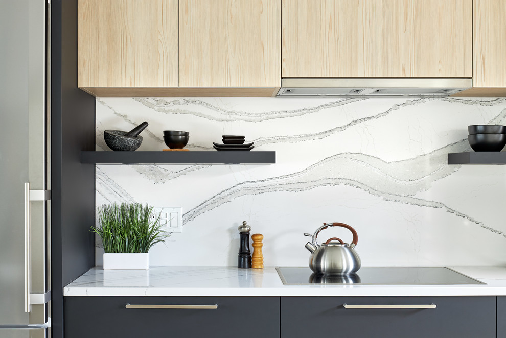Design ideas for a mid-sized modern single-wall eat-in kitchen in Toronto with a triple-bowl sink, flat-panel cabinets, black cabinets, quartz benchtops, white splashback, stainless steel appliances, medium hardwood floors, with island, grey floor and white benchtop.