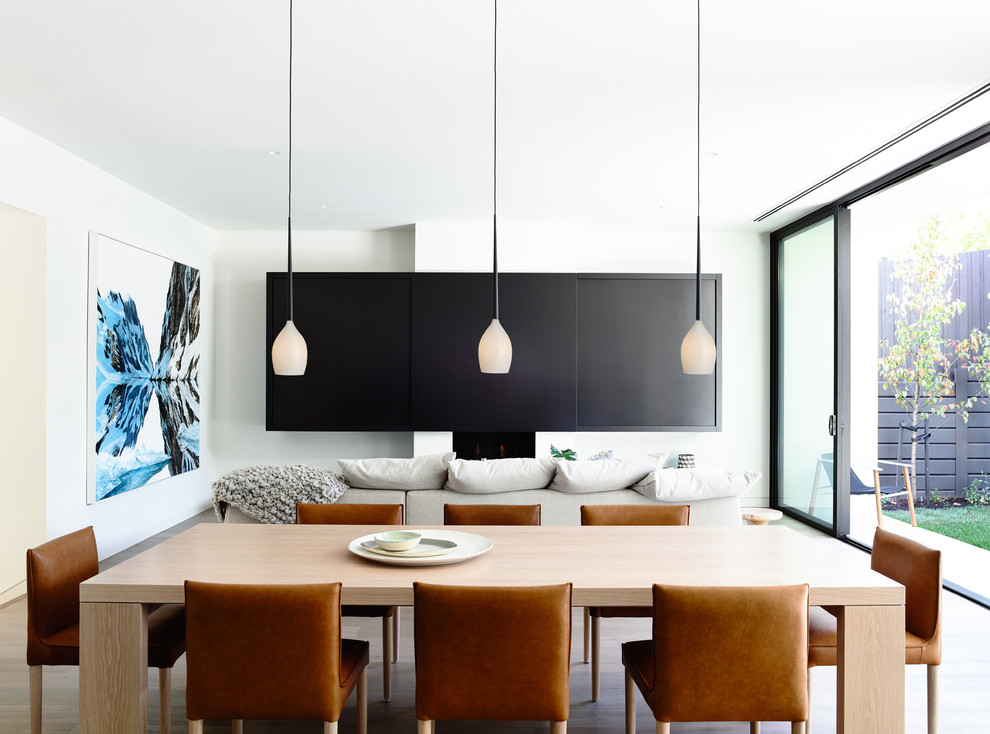 Large contemporary open plan dining in Melbourne with white walls, light hardwood floors, no fireplace and brown floor.