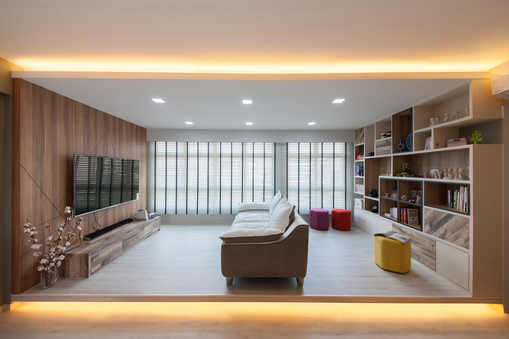 This is an example of a contemporary living room in Singapore with light hardwood floors, a wall-mounted tv and beige floor.