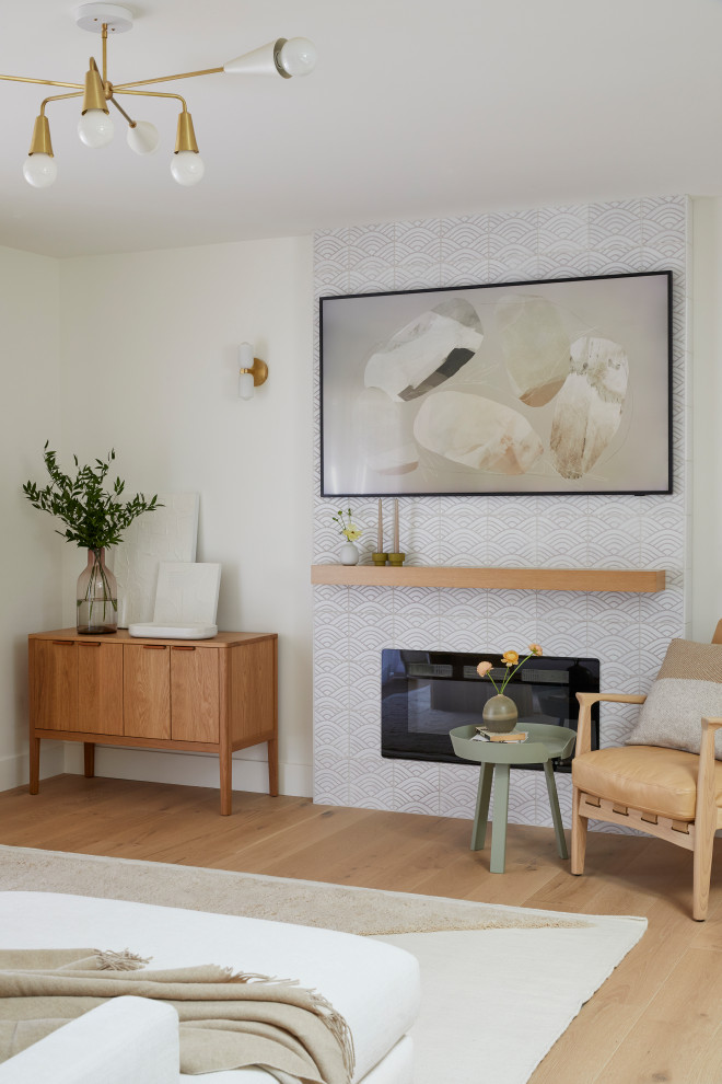 Idée de décoration pour un petit salon nordique ouvert avec un mur blanc, parquet clair, une cheminée standard, un manteau de cheminée en carrelage, un téléviseur fixé au mur et un sol marron.
