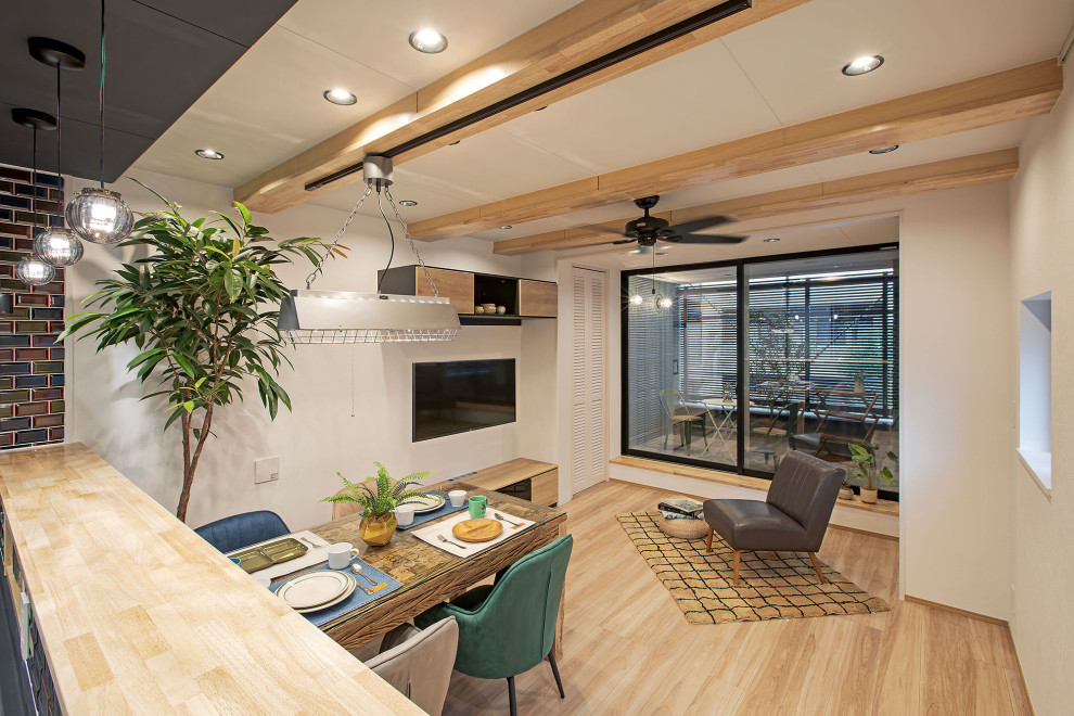 東京23区にある中くらいなインダストリアルスタイルのおしゃれなLDK (白い壁、暖炉なし、茶色い床、表し梁、壁紙、白い天井) の写真