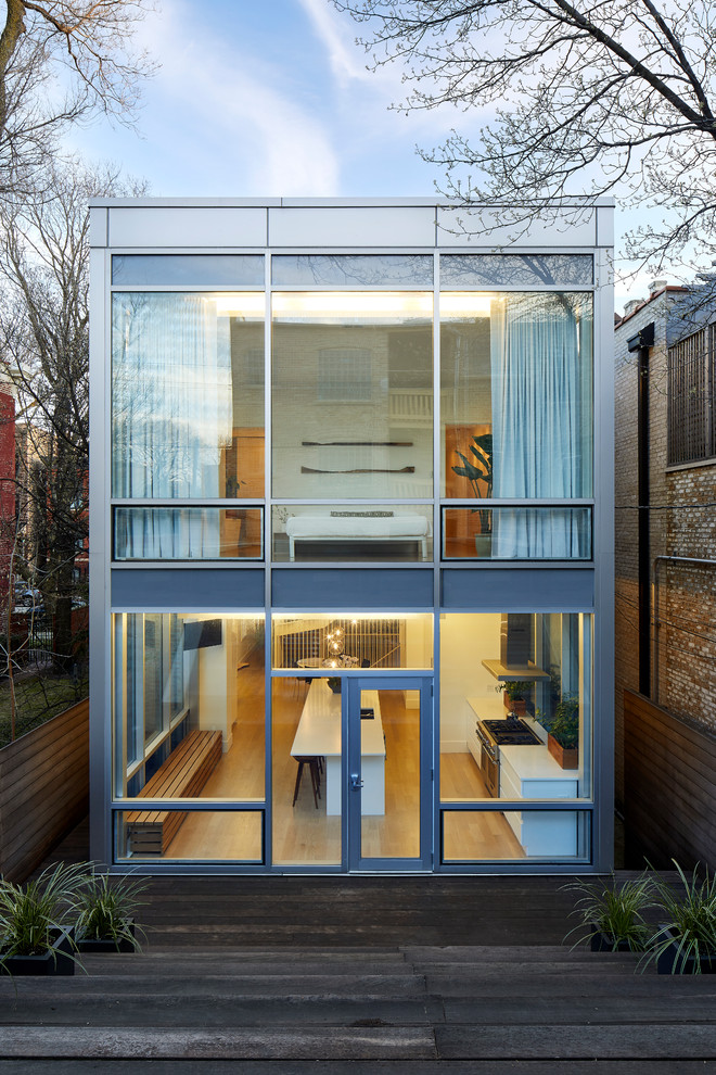 Design ideas for a large contemporary two-storey glass house exterior in Chicago with a flat roof.