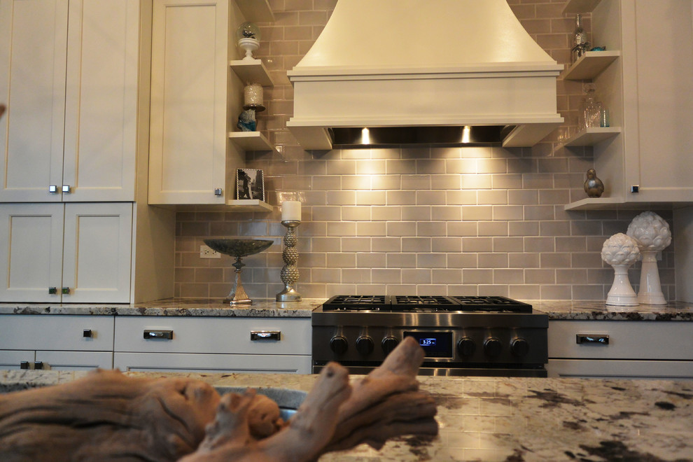 Example of a transitional l-shaped eat-in kitchen design in Chicago with a single-bowl sink, recessed-panel cabinets, white cabinets, quartzite countertops, gray backsplash, subway tile backsplash and stainless steel appliances
