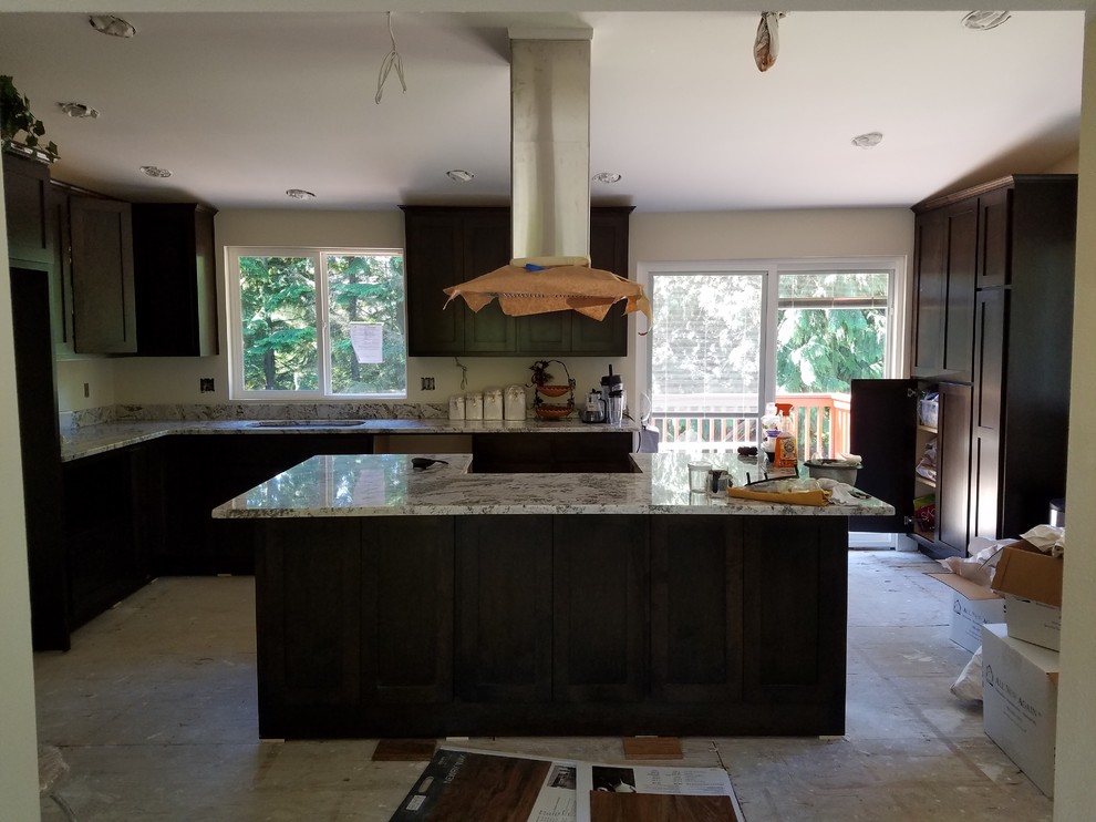 Example of a large transitional l-shaped light wood floor eat-in kitchen design in Seattle with an undermount sink, shaker cabinets, brown cabinets, granite countertops, white backsplash, stainless steel appliances, an island and white countertops
