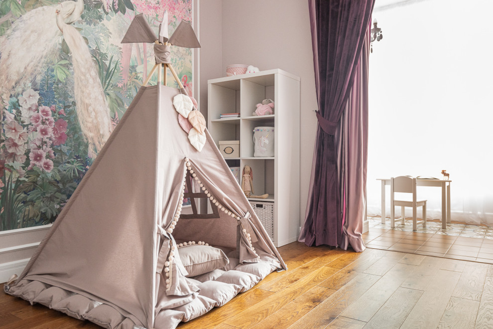Esempio di una cameretta per bambini da 1 a 3 anni design di medie dimensioni con pareti rosa, pavimento in legno massello medio, pavimento marrone e carta da parati