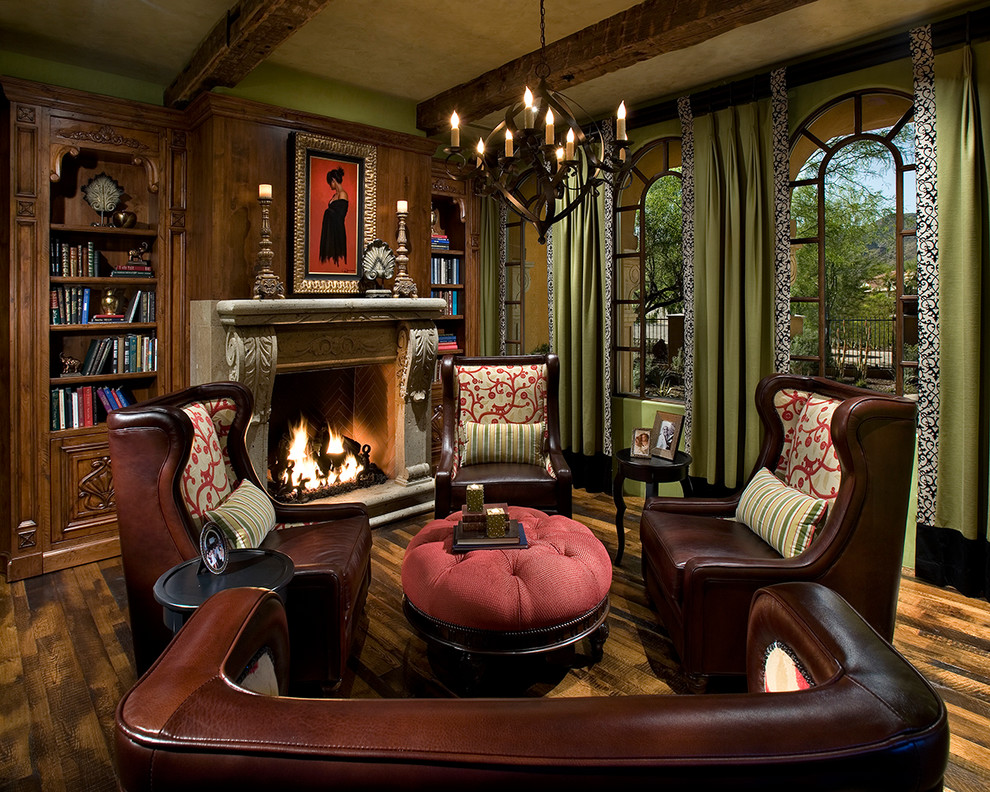 Photo of a large traditional enclosed living room in Orange County with a library, a standard fireplace, medium hardwood floors, a stone fireplace surround and brown floor.