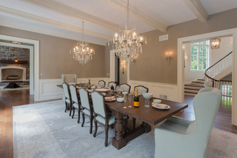 This is an example of a large eclectic separate dining room in Chicago with beige walls, medium hardwood floors, a standard fireplace, a stone fireplace surround and brown floor.