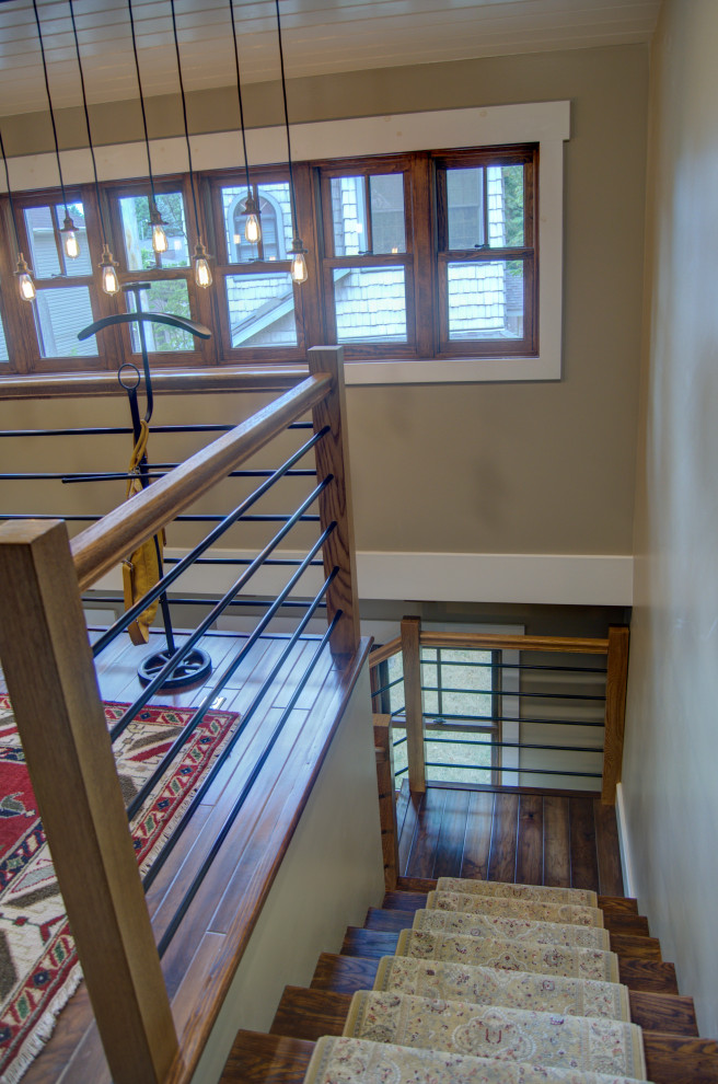 Идея дизайна: маленькая угловая лестница в стиле кантри с деревянными ступенями, крашенными деревянными подступенками, металлическими перилами и панелями на части стены для на участке и в саду