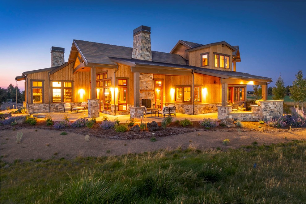 Example of a large mountain style brown two-story wood gable roof design