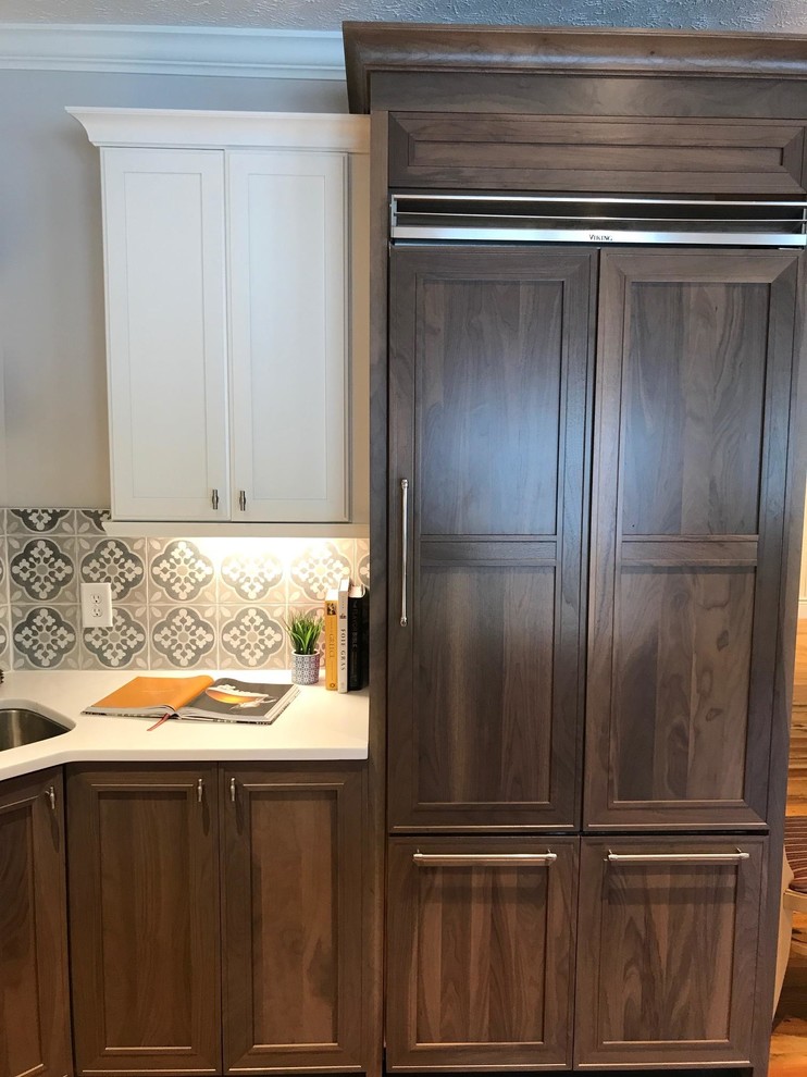 Photo of a large country l-shaped eat-in kitchen in Raleigh with an undermount sink, shaker cabinets, quartz benchtops, cement tile splashback, stainless steel appliances, medium hardwood floors, with island and brown floor.