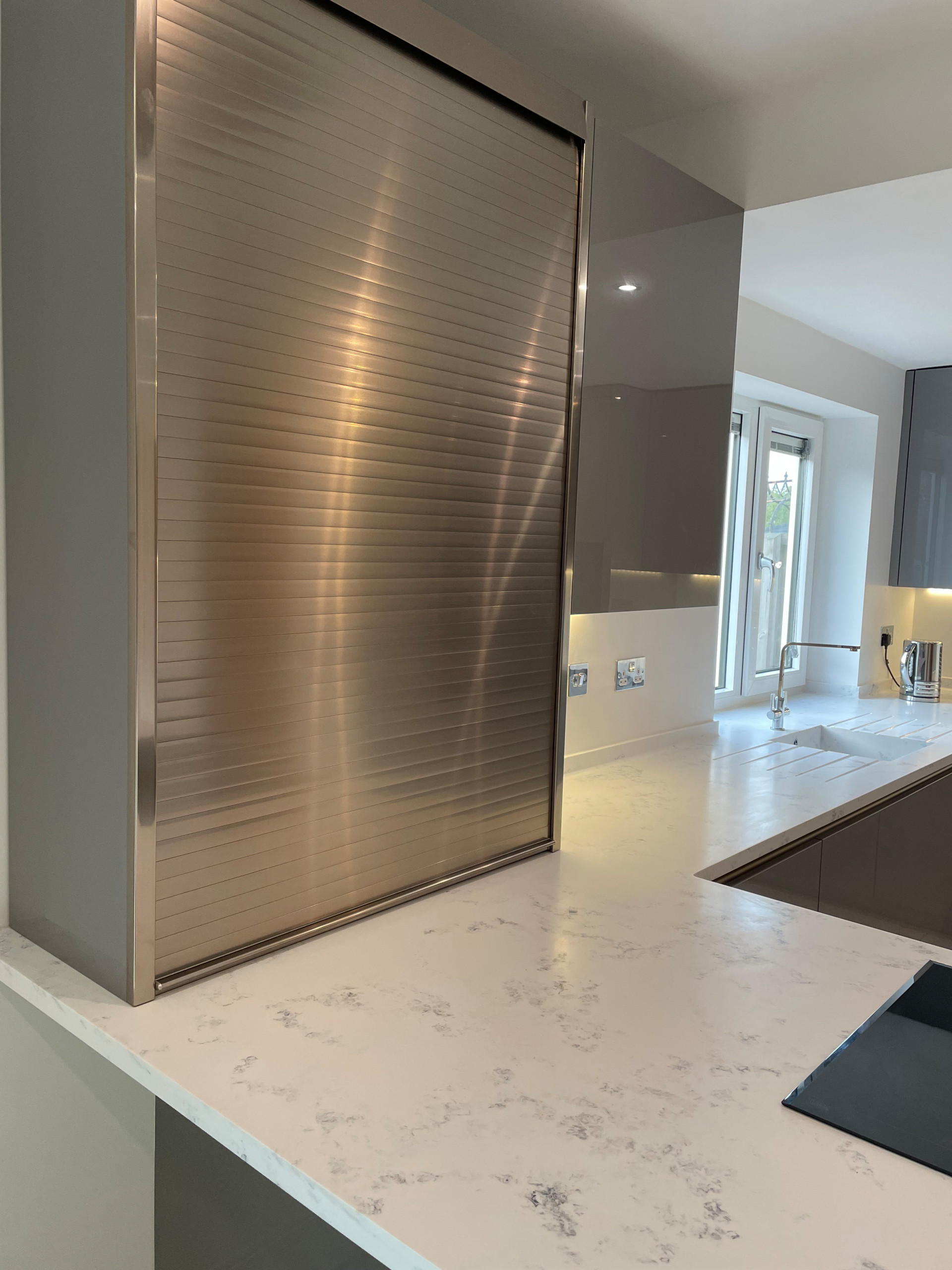 High Gloss Gravel Handleless Kitchen with White and Grey Solid Surface Tops