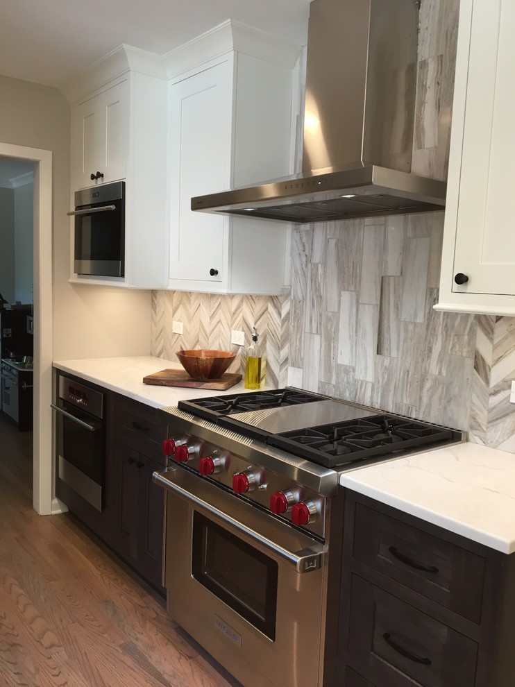 Example of a small transitional galley medium tone wood floor and brown floor eat-in kitchen design in Chicago with a farmhouse sink, shaker cabinets, gray cabinets, quartzite countertops, gray backsplash, stone tile backsplash, stainless steel appliances, no island and white countertops
