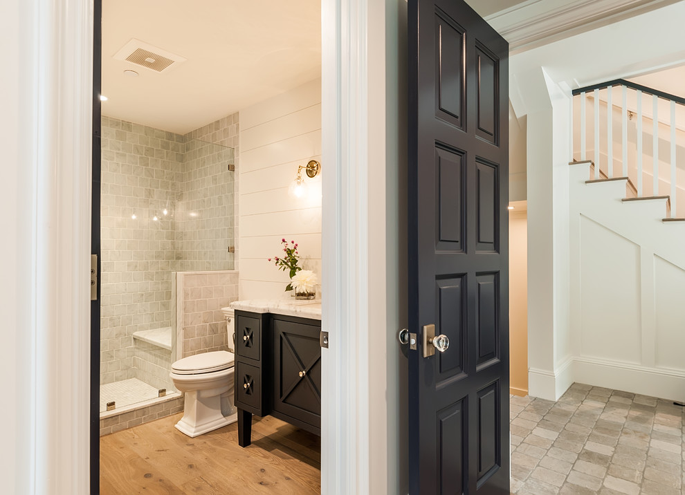 This is an example of a large country 3/4 bathroom in San Diego with recessed-panel cabinets, an alcove shower, white tile, marble, grey walls, marble floors, an undermount sink, marble benchtops, grey floor, a hinged shower door, white benchtops and black cabinets.