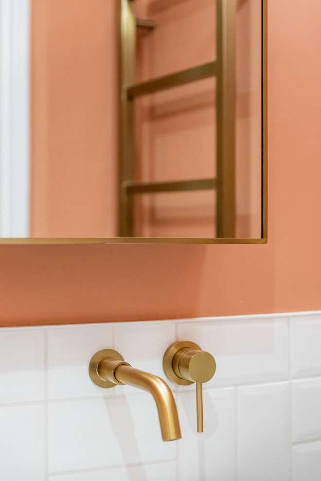 Kleines Kinderbad mit braunen Schränken, rosa Wandfarbe, Sockelwaschbecken, Waschtisch aus Holz, brauner Waschtischplatte, Einzelwaschbecken, schwebendem Waschtisch und braunen Fliesen in London