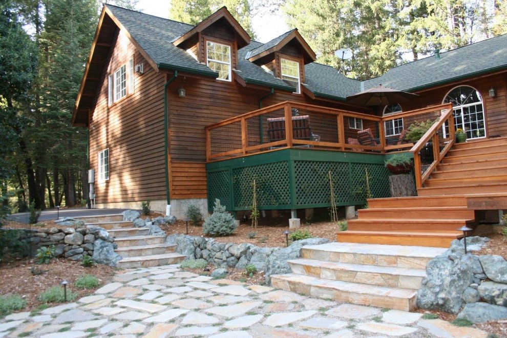 This is an example of a mid-sized rustic partial sun backyard stone landscaping in Sacramento.