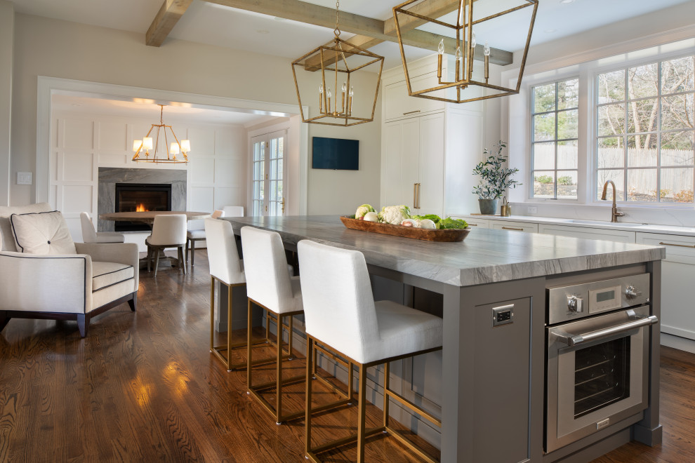 Example of a transitional l-shaped medium tone wood floor, brown floor and coffered ceiling open concept kitchen design in DC Metro with an undermount sink, recessed-panel cabinets, white cabinets, quartzite countertops, marble backsplash, paneled appliances, an island and gray countertops