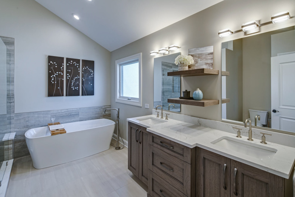 This is an example of a large transitional master bathroom in Chicago with recessed-panel cabinets, grey cabinets, a freestanding tub, an alcove shower, wood-look tile, an undermount sink, engineered quartz benchtops, grey floor, an open shower, grey benchtops, a niche, a double vanity and a freestanding vanity.