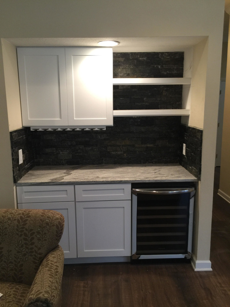 Enclosed kitchen - large transitional u-shaped dark wood floor and brown floor enclosed kitchen idea in Tampa with shaker cabinets, white cabinets, marble countertops, black backsplash, cement tile backsplash, black appliances and no island
