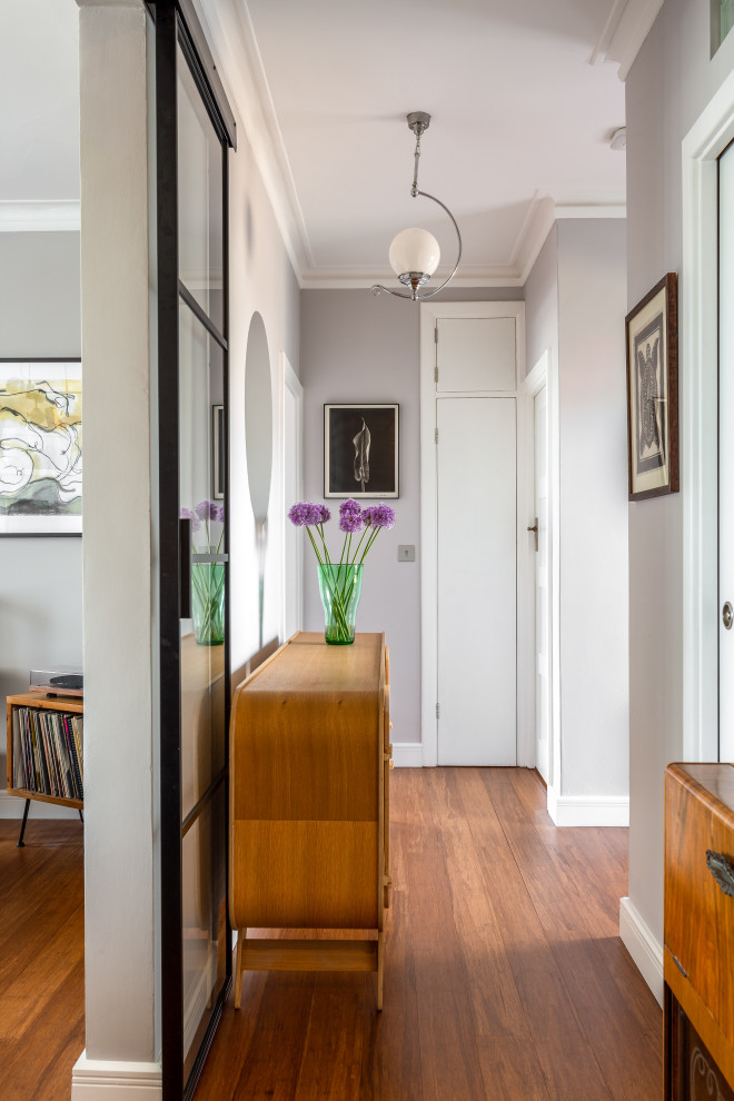 Inspiration for a mid-sized eclectic hallway in Sussex with grey walls, bamboo floors and brown floor.