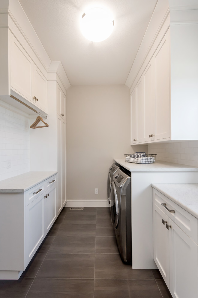 This is an example of a mid-sized traditional galley dedicated laundry room in Other with a single-bowl sink, shaker cabinets, white cabinets, laminate benchtops, beige walls, ceramic floors, a side-by-side washer and dryer, grey floor and white benchtop.