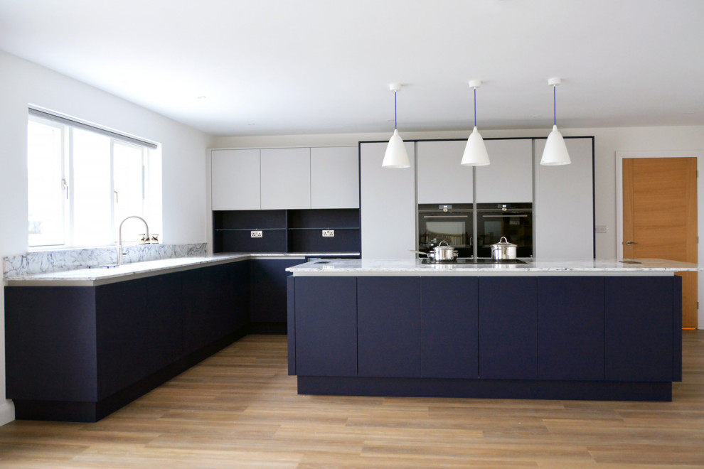 Offene, Mittelgroße Moderne Küche in L-Form mit flächenbündigen Schrankfronten, blauen Schränken, Quarzit-Arbeitsplatte und Kücheninsel in Cornwall