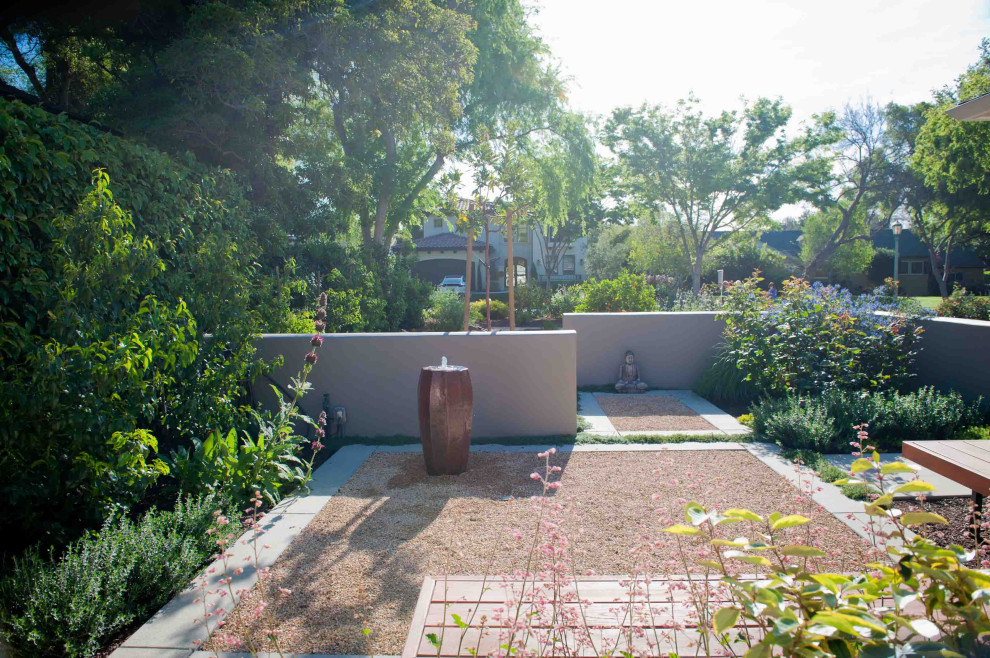 Exempel på en mellanstor modern uteplats framför huset, med en fontän och granitkomposit