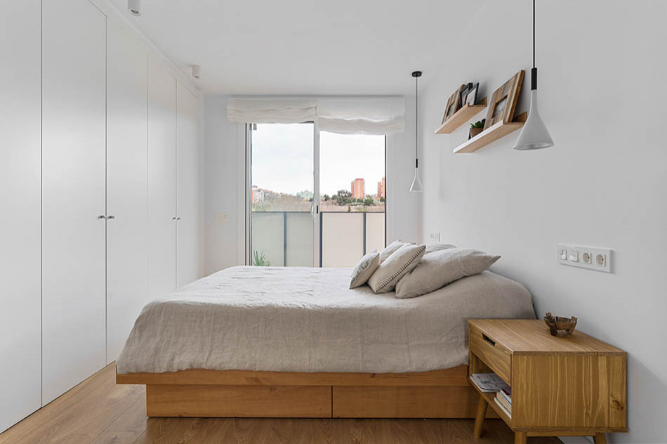 バルセロナにある中くらいな地中海スタイルのおしゃれな主寝室 (白い壁、ラミネートの床、茶色い床)