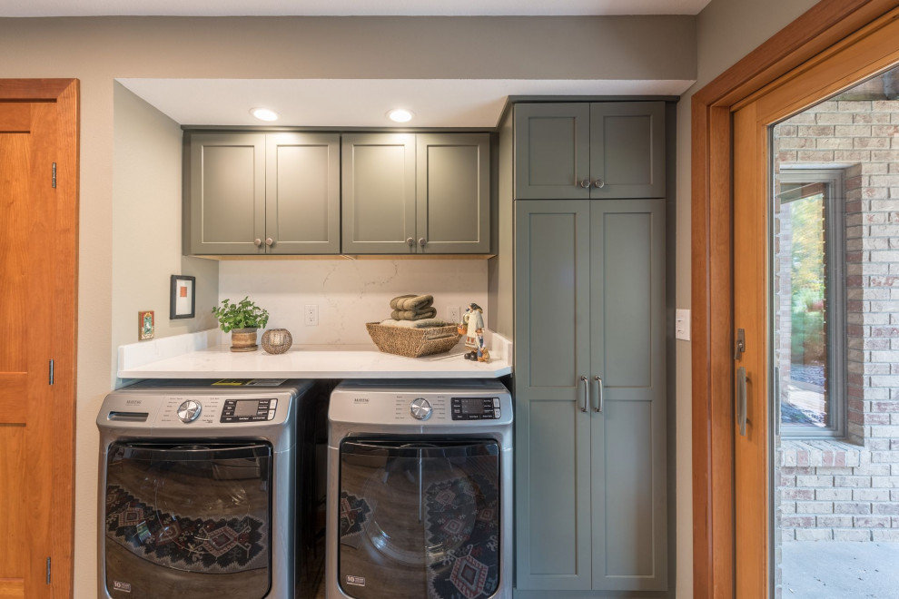 This is an example of a mid-sized transitional galley laundry room in Minneapolis with an undermount sink, shaker cabinets, grey cabinets, quartzite benchtops, white splashback, stone slab splashback, linoleum floors, brown floor and white benchtop.
