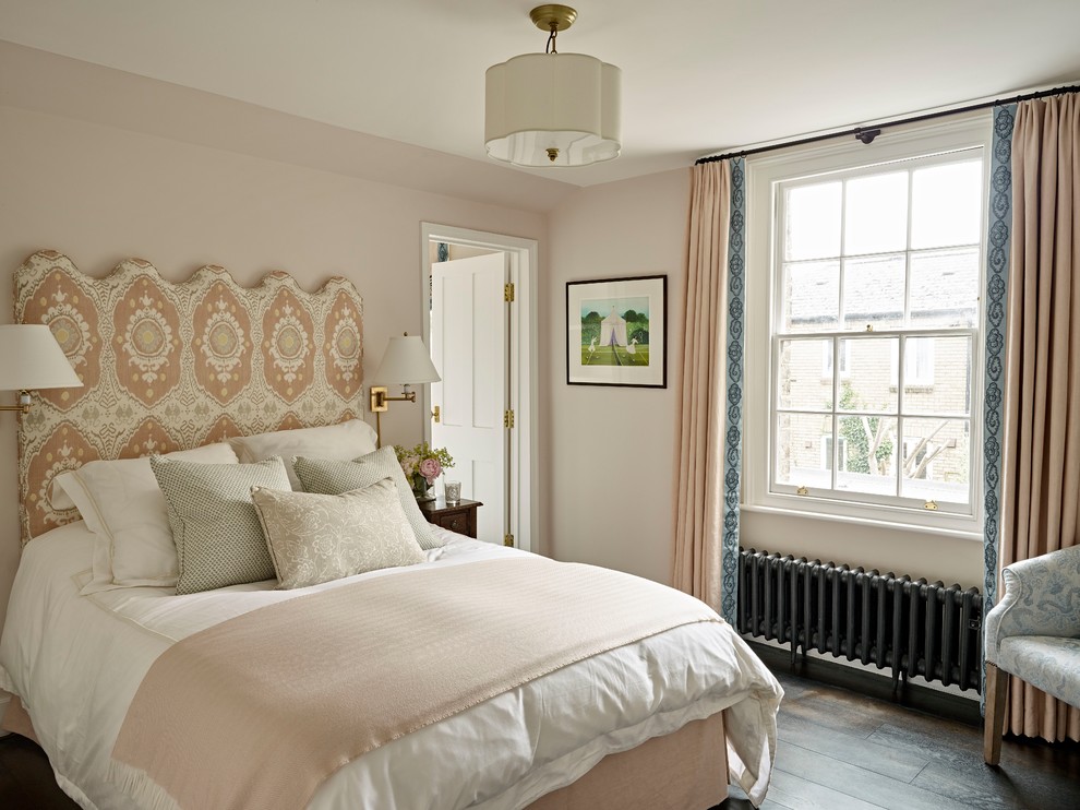 This is an example of a mid-sized traditional guest bedroom in London with beige walls, dark hardwood floors and brown floor.