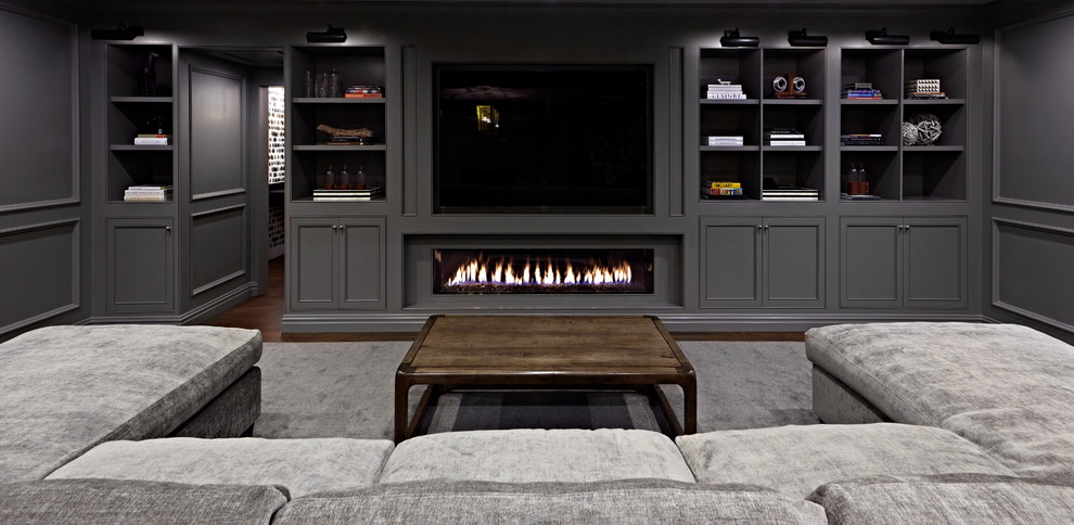 Photo of an expansive transitional fully buried basement in New York with grey walls, dark hardwood floors and a ribbon fireplace.
