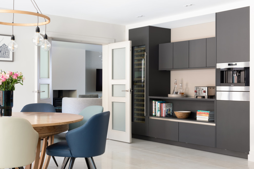 Large contemporary eat-in kitchen in Hertfordshire with an integrated sink, quartzite benchtops, black splashback, porcelain floors, with island, beige floor and black benchtop.