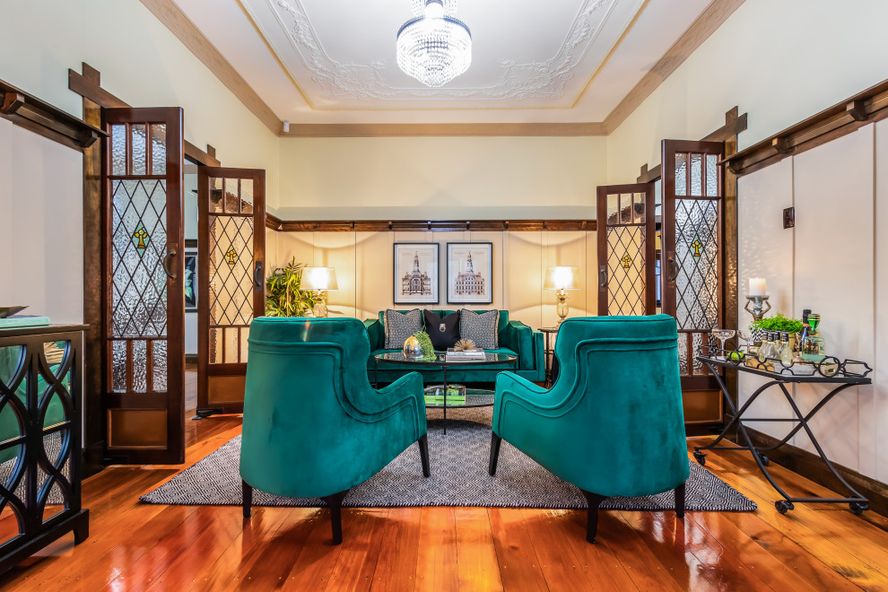 Traditional enclosed living room in Brisbane with white walls, medium hardwood floors, brown floor and panelled walls.