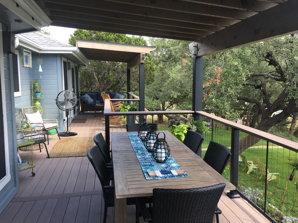 Photo of a large transitional backyard deck in Austin with a roof extension.