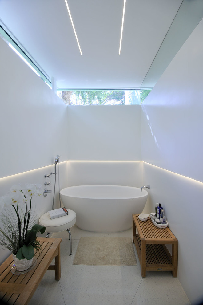 Design ideas for a contemporary bathroom in Miami with a freestanding tub, white walls and white floor.