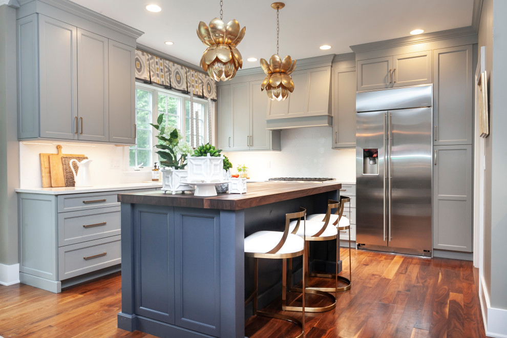 Inspiration for a large transitional l-shaped eat-in kitchen in Bridgeport with a farmhouse sink, recessed-panel cabinets, blue cabinets, wood benchtops, white splashback, ceramic splashback, stainless steel appliances, dark hardwood floors, with island, brown floor and brown benchtop.