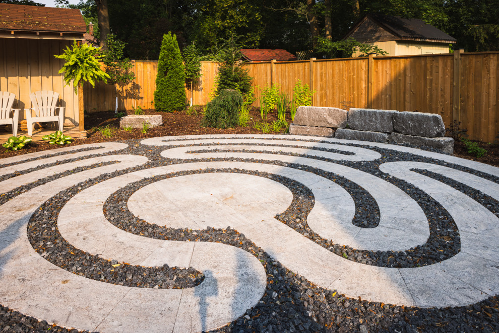 Photo of a mid-sized contemporary backyard partial sun garden in Toronto with with path and natural stone pavers.