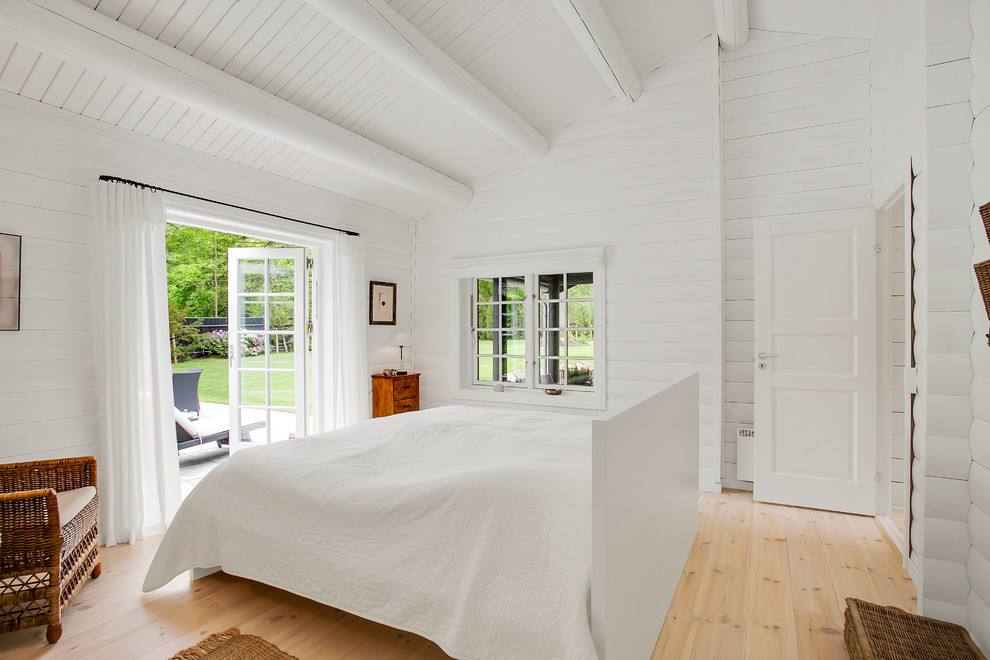 Design ideas for a mid-sized scandinavian master bedroom in Miami with white walls and light hardwood floors.
