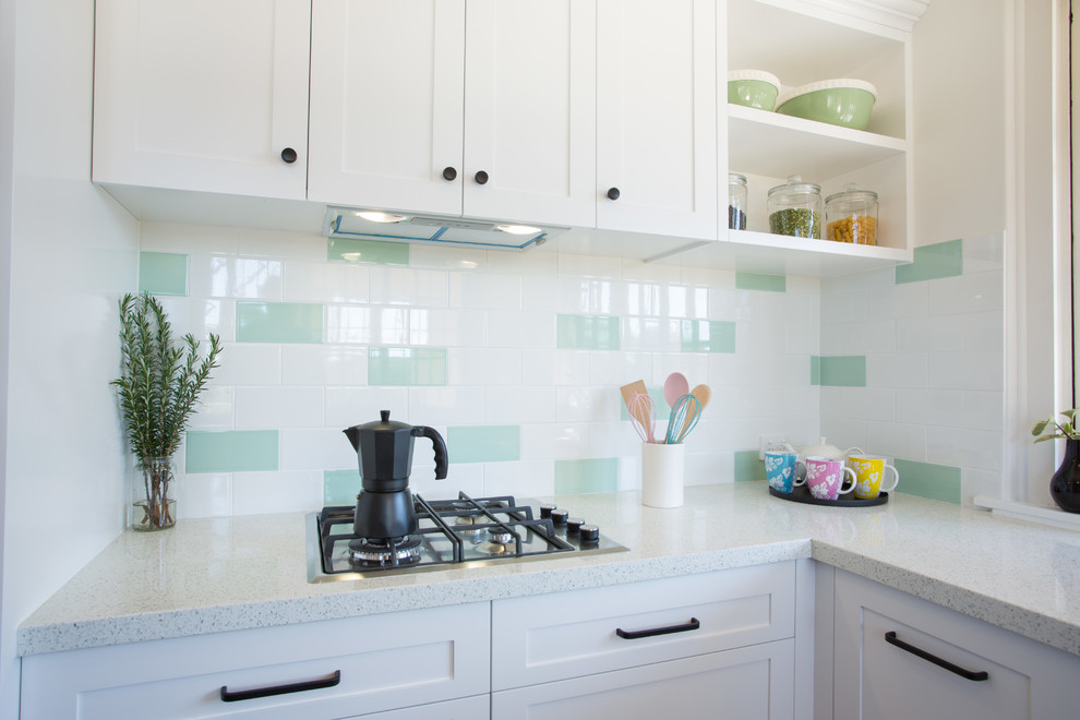Inspiration for a mid-sized traditional u-shaped separate kitchen in Brisbane with a double-bowl sink, shaker cabinets, white cabinets, quartz benchtops, green splashback, subway tile splashback, white appliances, dark hardwood floors, no island, red floor and white benchtop.