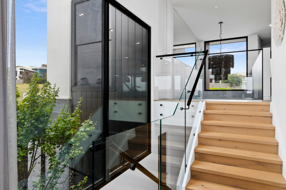 Inspiration for a large contemporary wood staircase in Geelong with glass railing.
