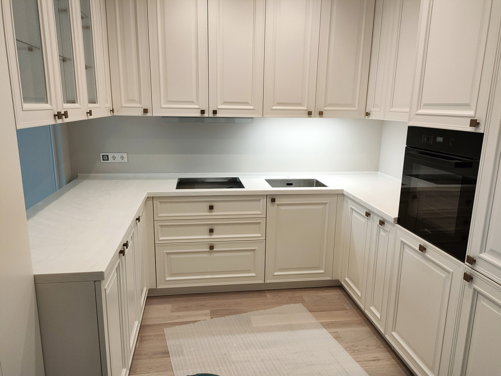 Immagine di una cucina minimal di medie dimensioni con top in superficie solida e top bianco