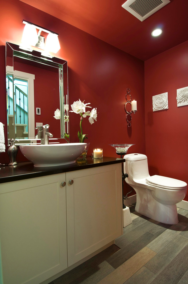 This is an example of a small traditional powder room in Vancouver with a vessel sink, shaker cabinets, engineered quartz benchtops, a one-piece toilet, multi-coloured tile, red walls, porcelain floors and beige cabinets.